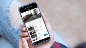 Xfinity Camera Pets on a mobile device being held by a woman