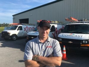 Man with arm crossed in front of his truck