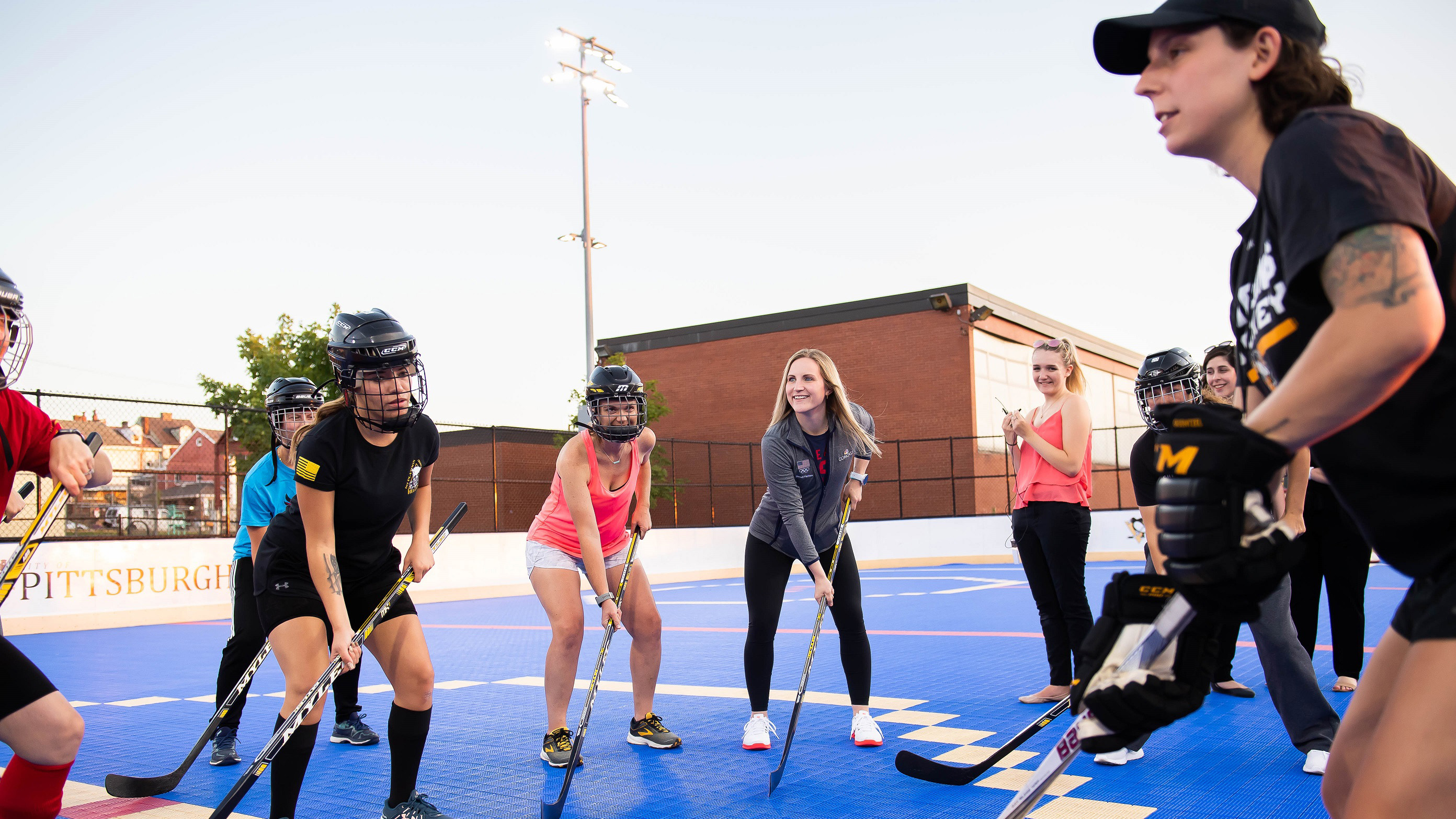 Jocelyne Lamoureux-Davidson and Monique Lamoureux-Morando play hockey with Internet Essentials participants.