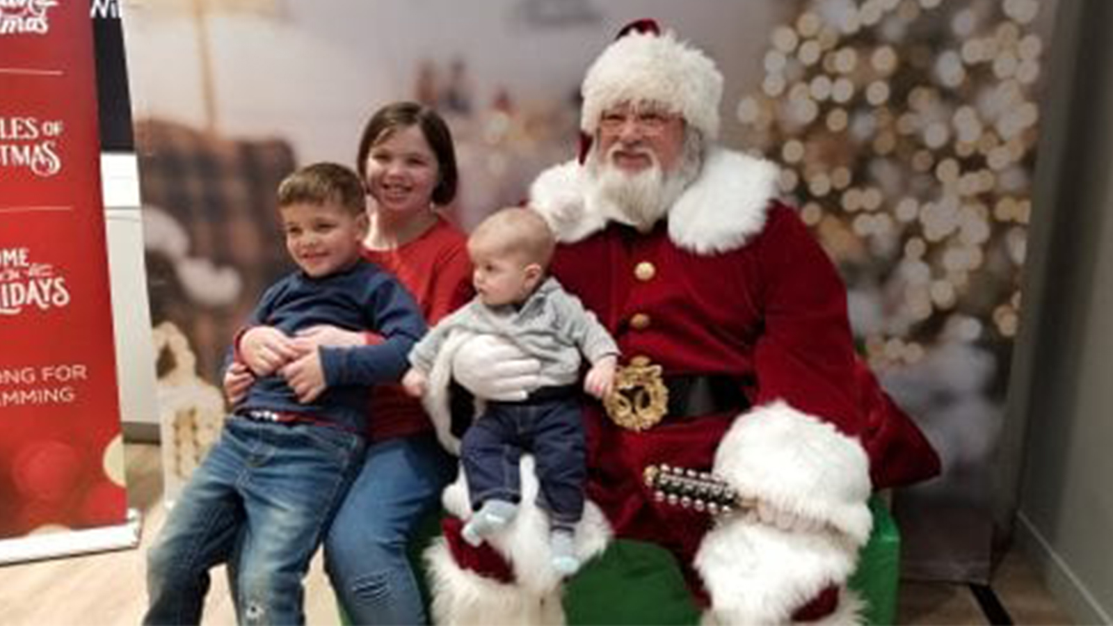 children sitting on Santa's lap inside an Xfinity Store