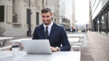 Man typing on a laptop outside