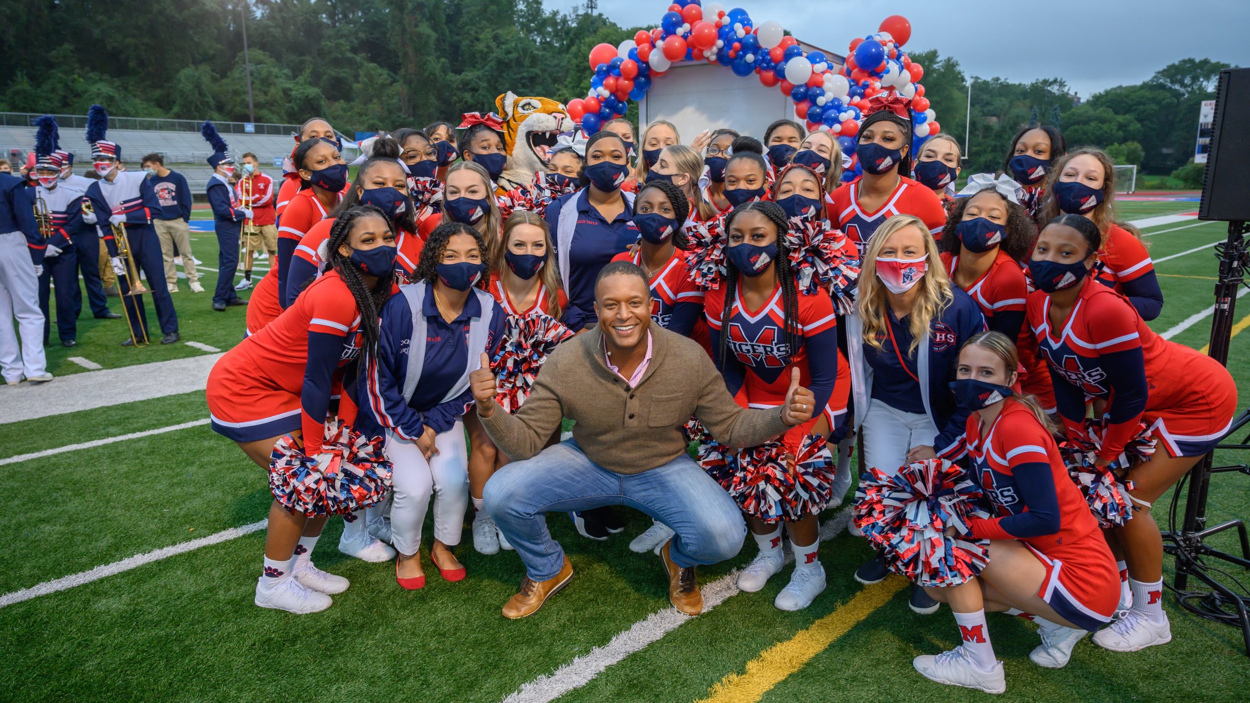 Craig Melvin surrounded by cheerleaders